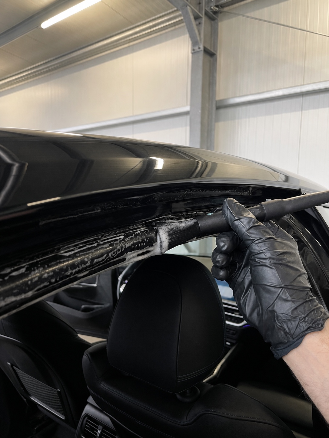 Detailpinsel bei der Reinigung einer oberen Fahrzeugtürdichtung