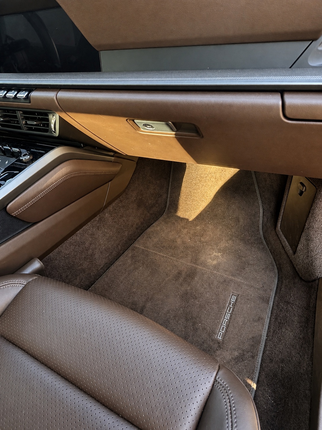 Beifahrerfußraum eines Porsche 911 mit sichtbaren Ablagerungen vor der Innenraumreinigung