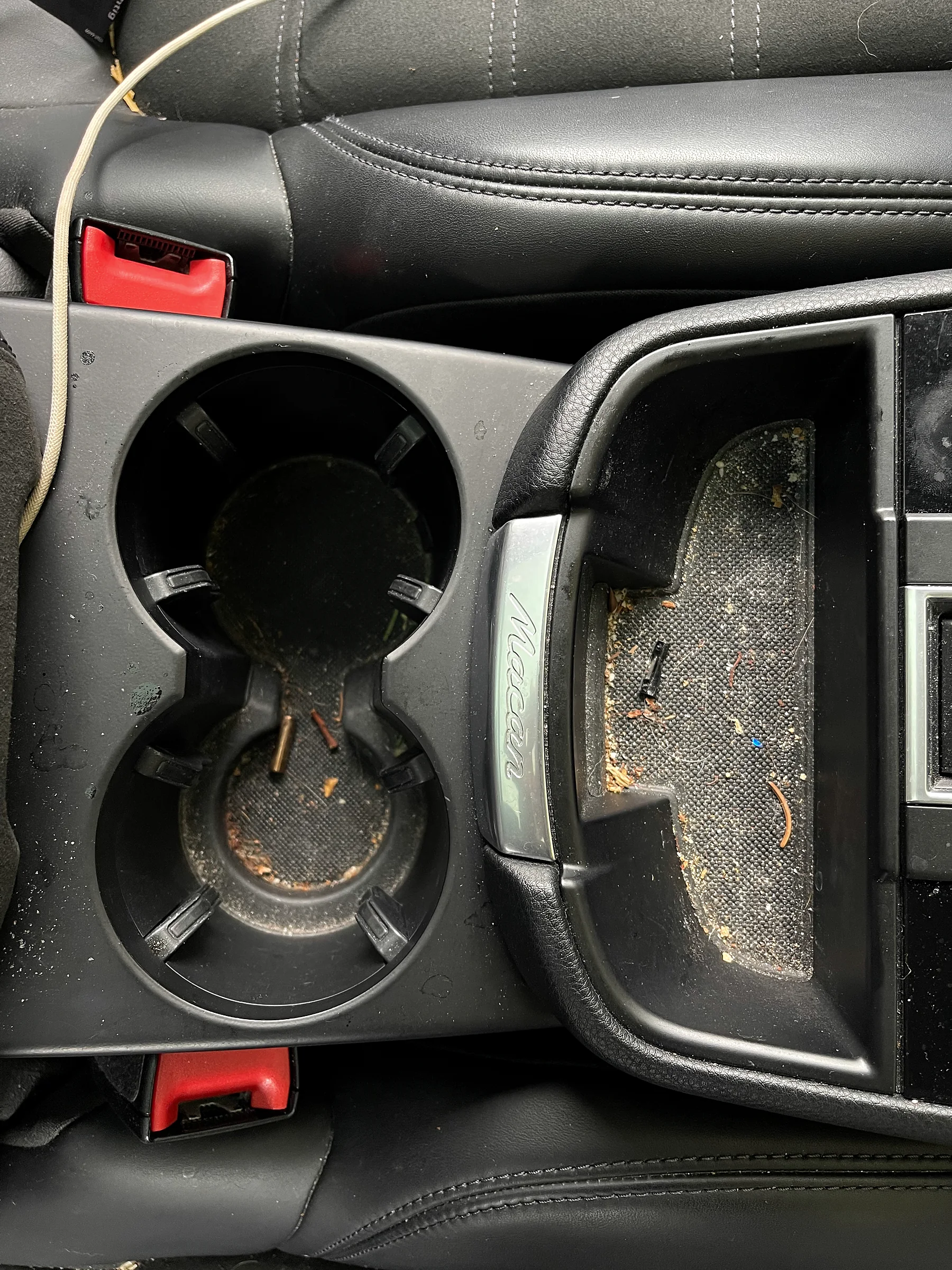 Verschmutzte Getränkehalter im Porsche Macan